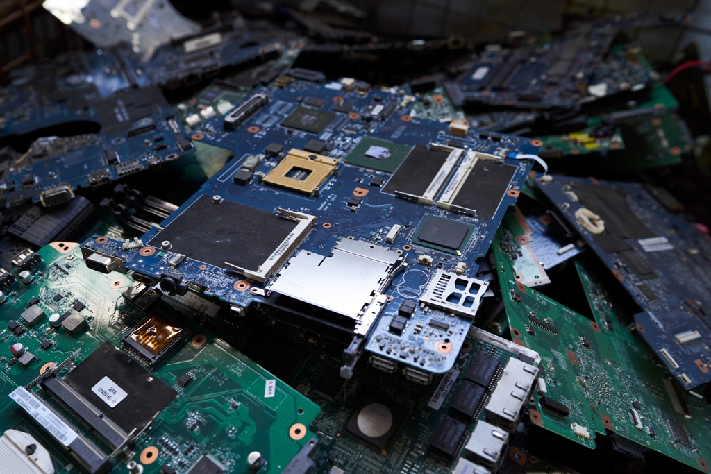 Haufenweise elektronische Platinen aus ausgedienten Geräten – Elektroschrott-Recycling in Nahaufnahme.